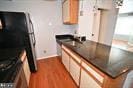 kitchen featuring dark countertops, dark wood-type flooring, and baseboards