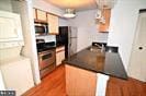 kitchen with dark countertops, wood finished floors, and stainless steel appliances