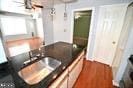 kitchen featuring a sink, dark countertops, and dark wood-style floors