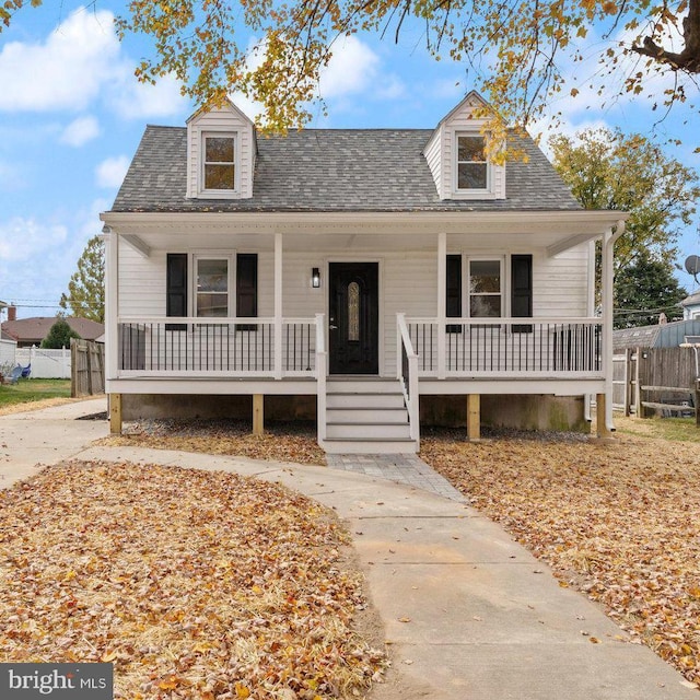 view of front facade featuring roof with shingles, a porch, and fence