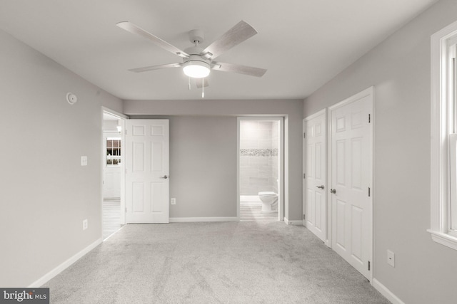 unfurnished bedroom with carpet flooring, ensuite bath, and baseboards