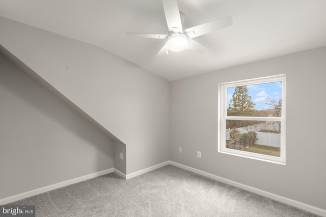 unfurnished room with lofted ceiling, carpet, baseboards, and ceiling fan