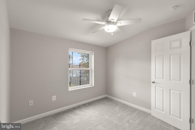 spare room with carpet flooring, a ceiling fan, and baseboards