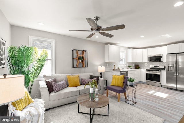 living room with recessed lighting, a ceiling fan, and light wood finished floors