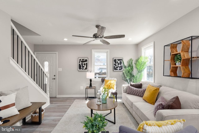 living room featuring stairway, wood finished floors, baseboards, and a wealth of natural light