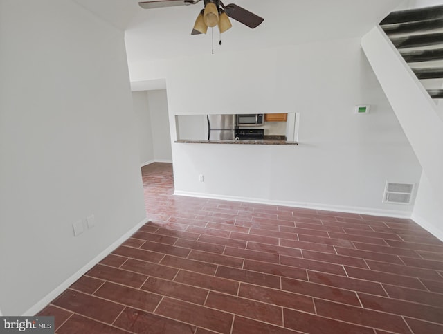 unfurnished living room with a ceiling fan, dark wood finished floors, baseboards, and visible vents