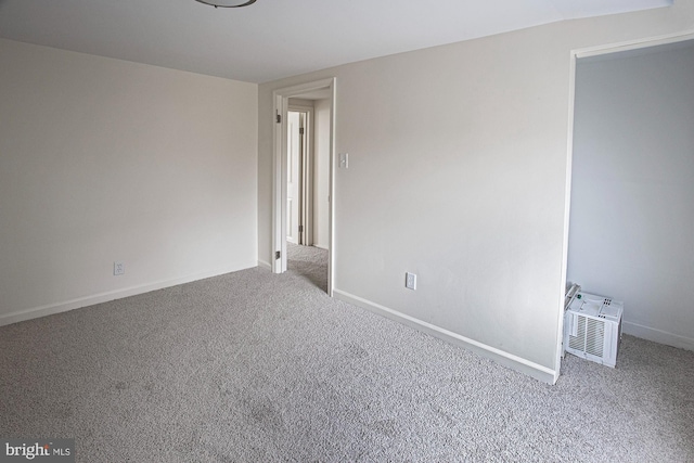 carpeted empty room featuring baseboards