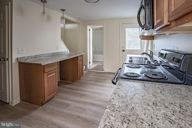 kitchen with brown cabinetry, a sink, electric stove, light wood-style floors, and black microwave