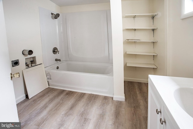 full bathroom featuring tub / shower combination, baseboards, wood finished floors, and vanity