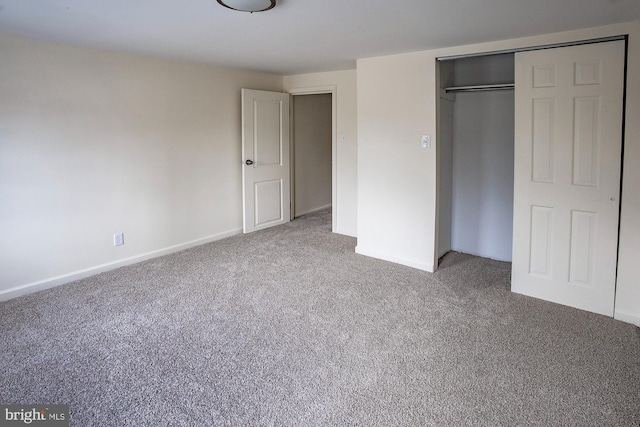 unfurnished bedroom with a closet, carpet flooring, and baseboards