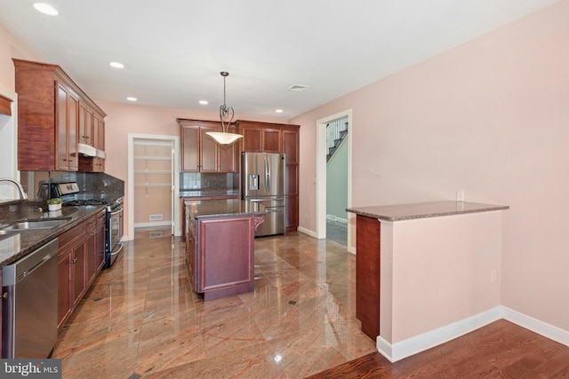 kitchen featuring a sink, baseboards, tasteful backsplash, and stainless steel appliances