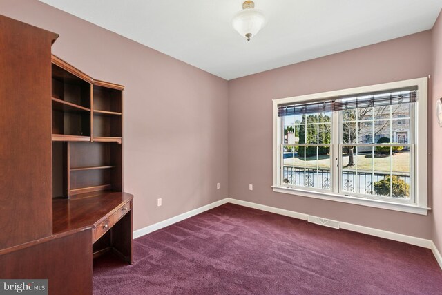 interior space with baseboards, visible vents, and dark carpet