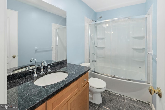 bathroom featuring combined bath / shower with glass door, toilet, and vanity