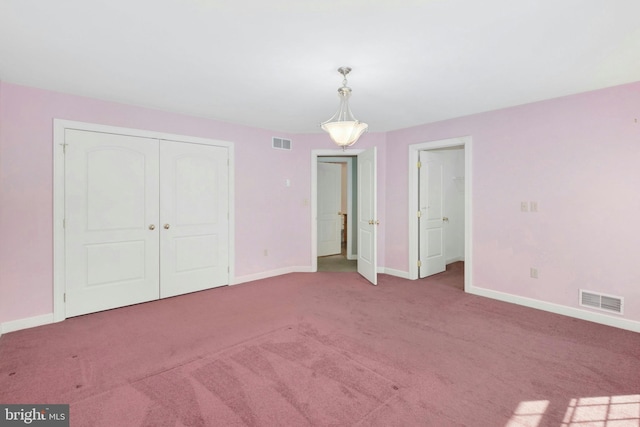 unfurnished bedroom with a closet, visible vents, carpet flooring, and baseboards