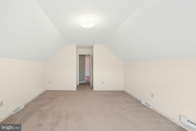 additional living space with a baseboard radiator, carpet floors, visible vents, and vaulted ceiling