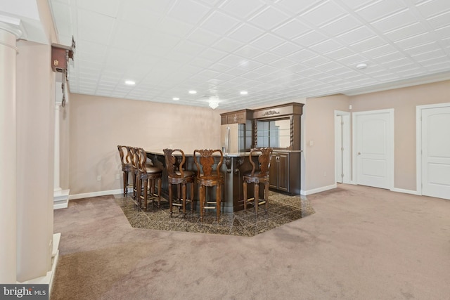 interior space with refrigerator with ice dispenser, recessed lighting, a bar, carpet flooring, and baseboards