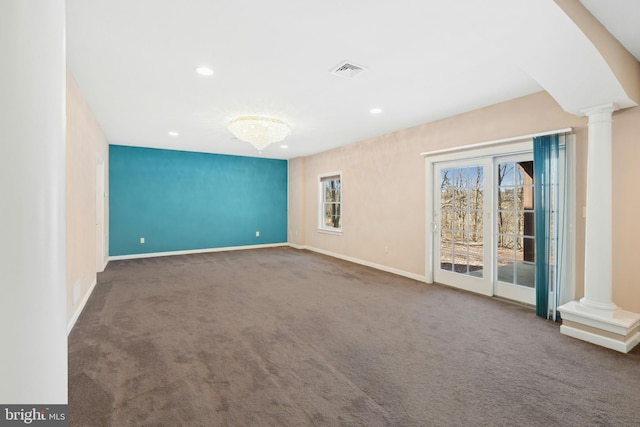 spare room featuring visible vents, baseboards, carpet, and ornate columns