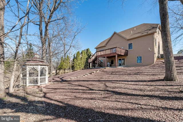 rear view of property with stairs, a gazebo, central AC, and a wooden deck