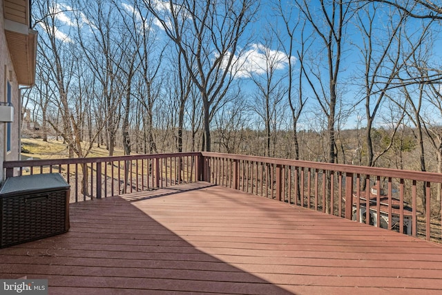 wooden deck with a wooded view