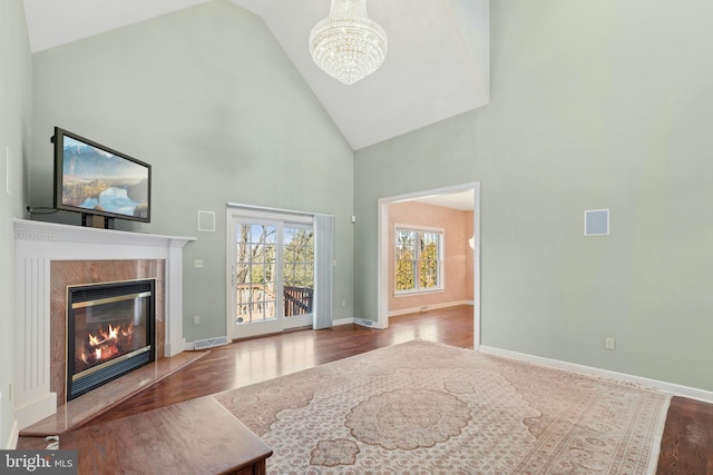 living area featuring visible vents, a notable chandelier, wood finished floors, a premium fireplace, and baseboards