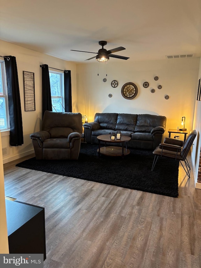 living area featuring visible vents, ceiling fan, and wood finished floors