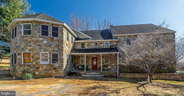 view of front of home with covered porch and stone siding