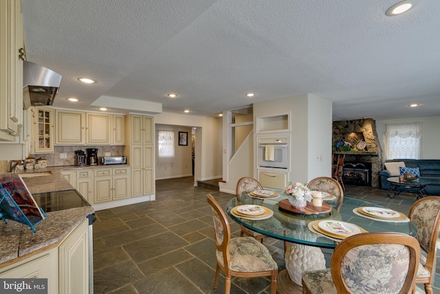 dining room with recessed lighting, baseboards, stone tile floors, and stairs