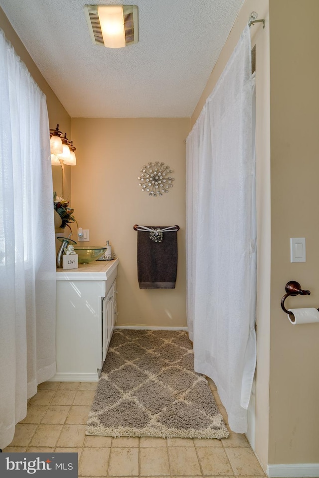 bathroom with visible vents, a textured ceiling, and vanity