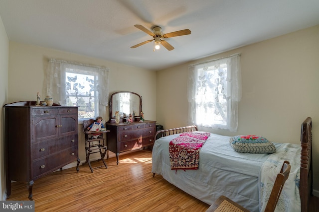 bedroom with multiple windows, wood finished floors, and ceiling fan