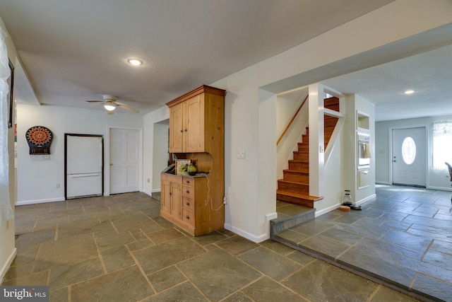 kitchen featuring baseboards, stone tile floors, recessed lighting, freestanding refrigerator, and a ceiling fan