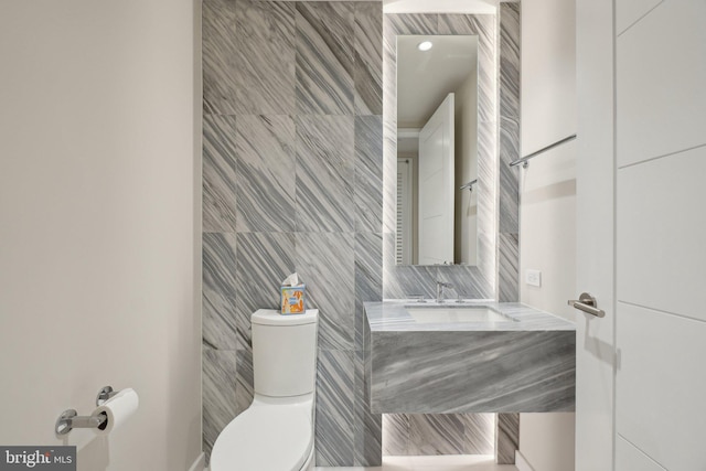 bathroom featuring toilet, tile walls, and vanity