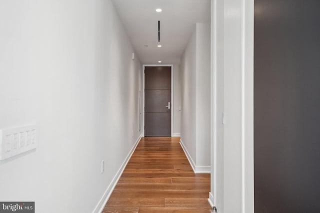 corridor featuring light wood-style flooring, recessed lighting, and baseboards