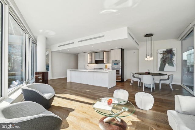 living area with baseboards and dark wood-style floors