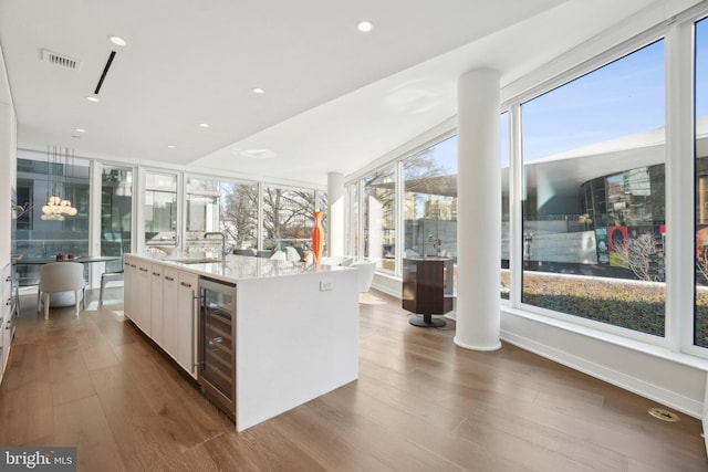 kitchen featuring wine cooler, dark wood-style floors, white cabinets, and visible vents