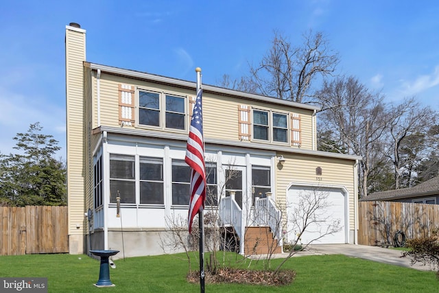 traditional-style home with fence, driveway, a chimney, a front lawn, and a garage