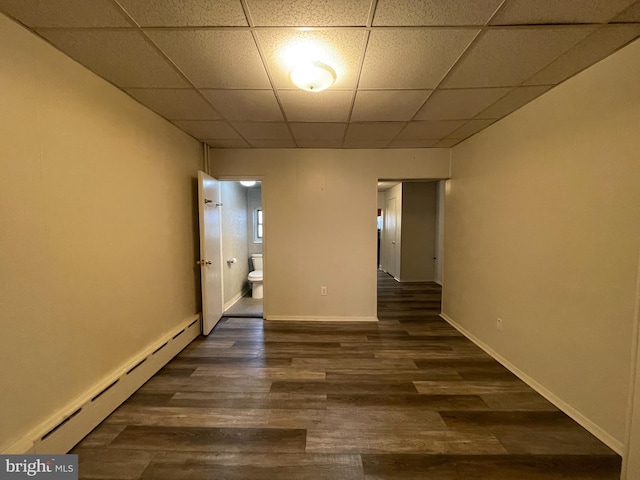 interior space with dark wood-style floors, baseboard heating, a paneled ceiling, and baseboards