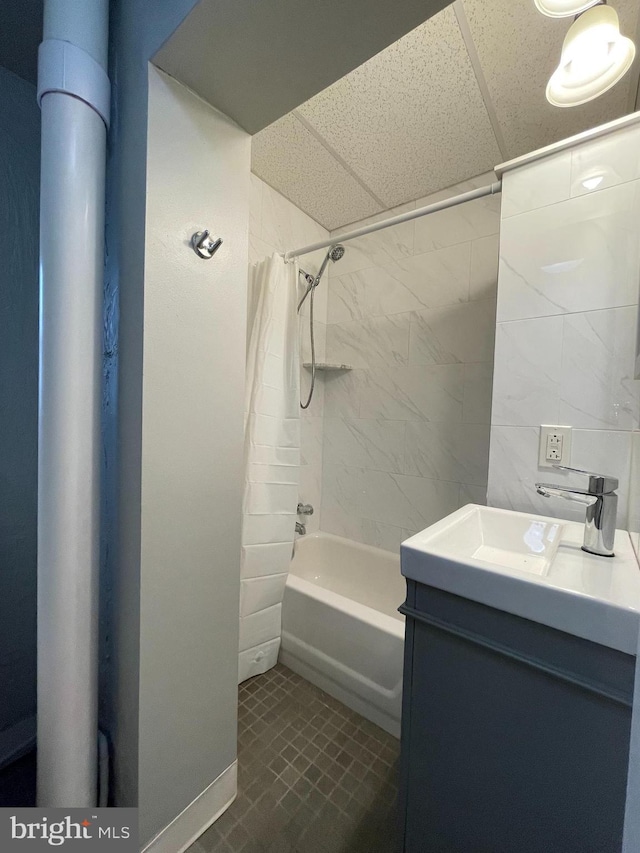 full bath with vanity, shower / bath combo with shower curtain, and a drop ceiling