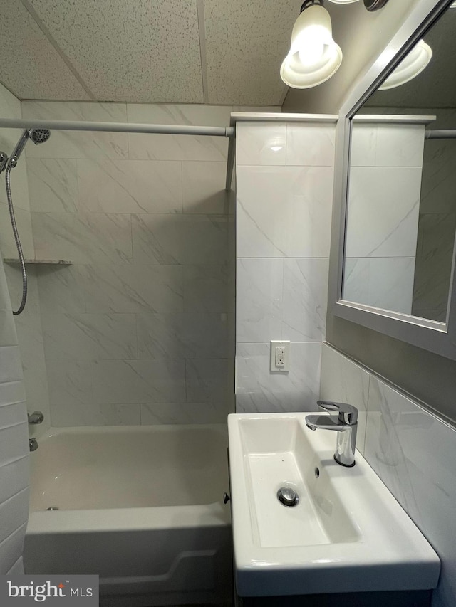 bathroom featuring tub / shower combination, tile walls, and vanity