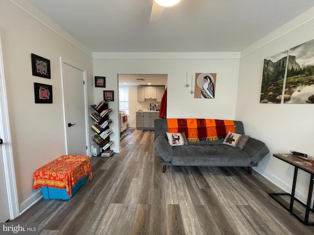 living room with baseboards, dark wood finished floors, and ornamental molding