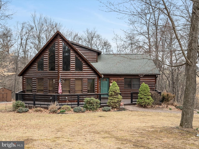 view of front of property featuring faux log siding and a shingled roof