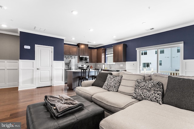 living room with crown molding, recessed lighting, dark wood-style floors, and visible vents