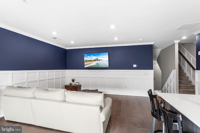 living area with a wainscoted wall, dark wood-style flooring, recessed lighting, crown molding, and stairs