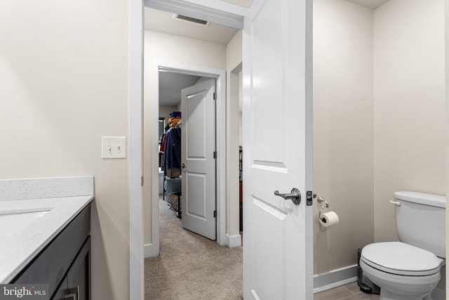 bathroom with visible vents, toilet, vanity, and baseboards