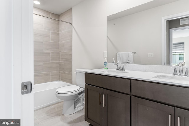 full bathroom with a sink, visible vents, toilet, and double vanity