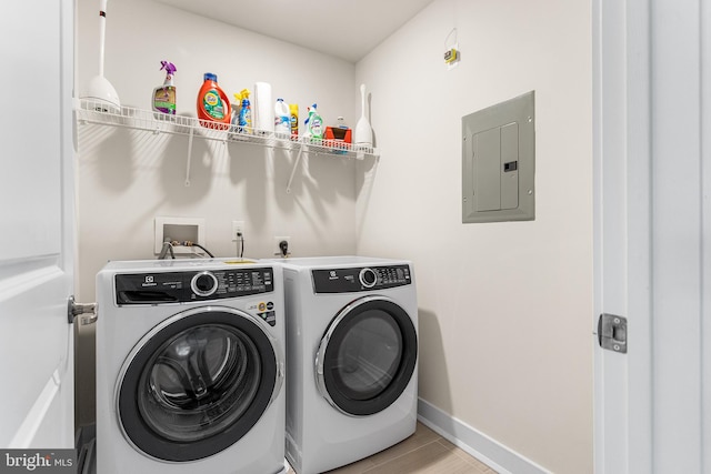 laundry room with electric panel, baseboards, laundry area, and washer and clothes dryer