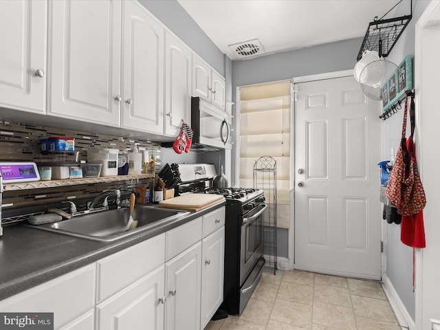 kitchen featuring visible vents, white cabinetry, stainless steel appliances, and a sink