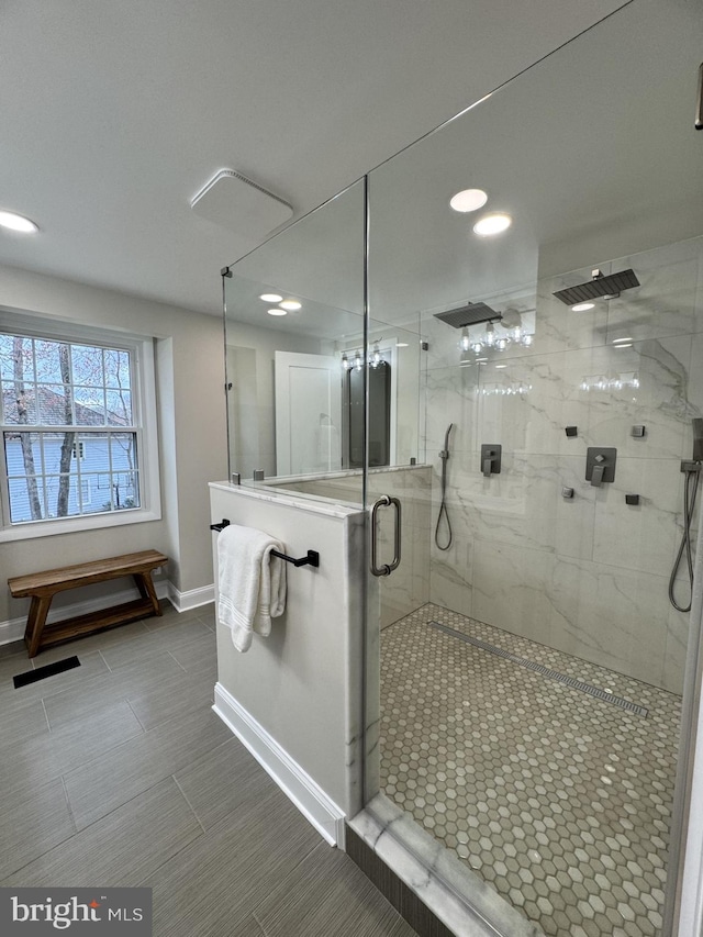 bathroom featuring visible vents, a shower stall, and baseboards