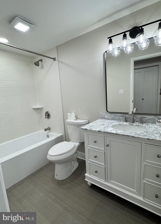 bathroom featuring toilet, vanity, and bathtub / shower combination