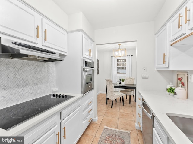 kitchen with under cabinet range hood, stainless steel appliances, light tile patterned floors, and white cabinetry