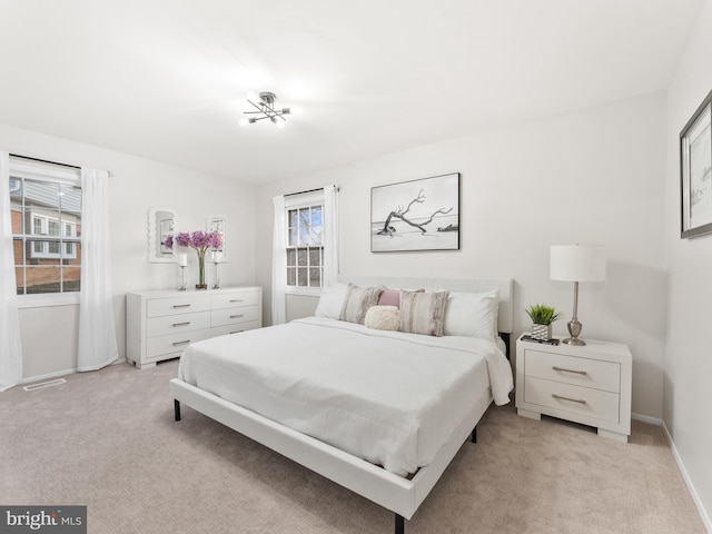 bedroom with visible vents, light colored carpet, and baseboards